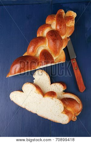 sweet bread : golden challah cuts over blue wooden plate