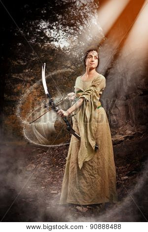 Elf Woman With The Magic Bow On The Autumn Forest Background.