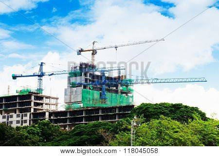 high buildings under construction with cranes at evening