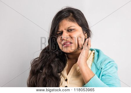 Closeup portrait young indian woman with sensitive tooth ache problem about to cry from pain touchin