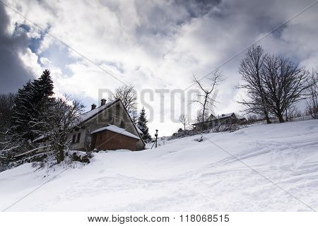 Snow Covered House In A Frosty Mountains Country In Sunny Winter Day