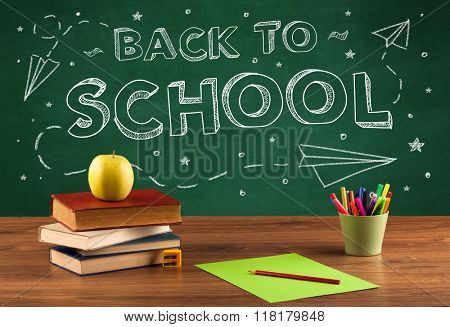 Back to school concepty with writing on blackboard and desk, apple, books, items