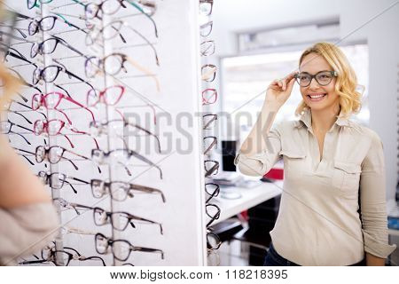 Pretty female try very nice frame for eyeglasses in optician shop