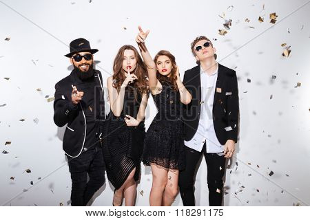 Group of attractive young friends standing ans gesturing over white background