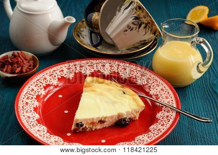 Homemade Cottage Cheese Cheesecake On Red Plate With Lemon Curd, Tea And Goji Berries