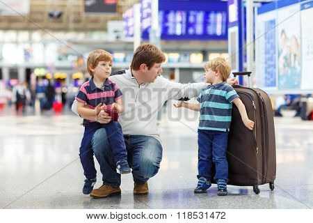 Tired father and two little sibling kids boys at the airport traveling together. Angry family waiting. Canceled flight due to pilot strike.