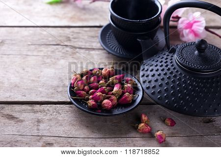 Dry Rose  Tea In Bowl And Traditional Asian Tea Set  On Aged Wooden Background.