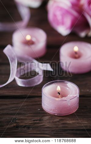 Pink Roses And Pinl Candles On The Wooden Table