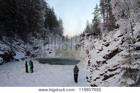 Karelia, Russia - January, 2016: People Are Photographed On The Background Waterfall Kivach In Cloud