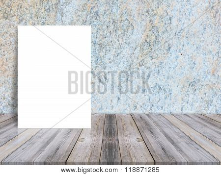 Blank white poster leaning at tropical wood table top with dark stone wall. Mock up background for adding content