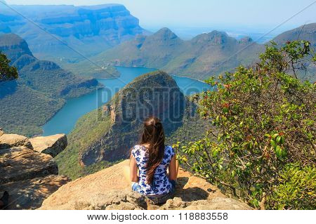 Girl sitting on stone on the cliff