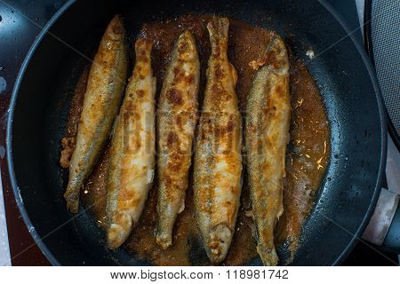 Fried small smelt tasty fish on a barbecue  hotplate
