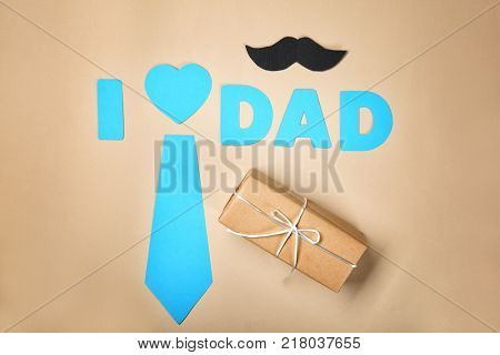 Composition with phrase I LOVE DAD and gift for Father's Day on craft paper