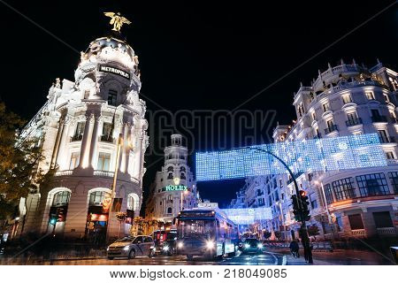 Madrid, Spain - December 8, 2017: Gran Via Street in Madrid at night on Christmas time. Long exposure shot with light trails of traffic and blurred people