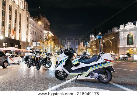 Madrid, Spain - December 8, 2017: Police motorbikes in the entrance to Gran Via Street of Madrid at night on Christmas time
