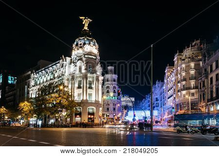 Madrid, Spain - December 8, 2017: Gran Via and Alcala streets in Madrid at night on Christmas time. Long exposure shot with light trails of traffic and blurred people