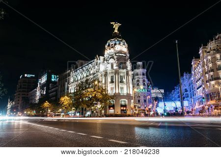Madrid, Spain - December 8, 2017: Gran Via and Alcala streets in Madrid at night on Christmas time. Long exposure shot with light trails of traffic and blurred people