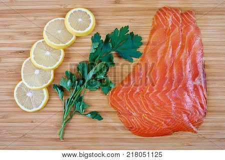 Fillet trout with fresh herbs and lemon on a board. Seafood.