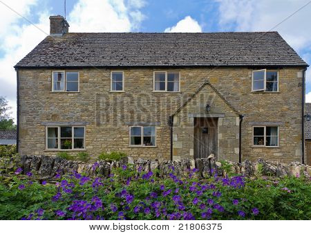 Chalupa s květinami v Upper Slaughter, Cotswolds, Velká Británie