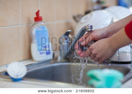 Lavaggio dei piatti - mani di donna lavaggio piatti sotto l'acqua corrente nel lavandino (colore dai toni imag
