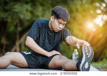 Sporty man stretching and warming up legs for running fitness  workout. Sport and healthy lifestyle concept. Man exercising outside.