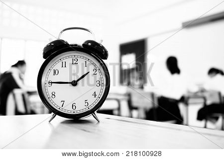 Alam clock located on wood teacher table in final exam room of secondary school college university classroom students in Asia Thailand. It show a timeout sign. in secondary school Education concept