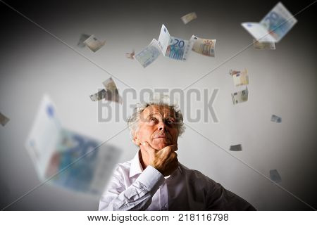 Old man in white and falling Euro banknotes. Currency and lottery concept.