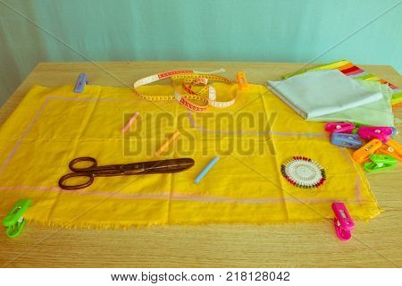 Tools for sewing for hobby set on wooden table background top view. Sewing kit. Thread needles and cloth. tailor workspace with sewing and handmade tools