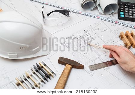 Concept architects or engineer holding pencil pointing equipment architects. On the desk with a blueprint in the office