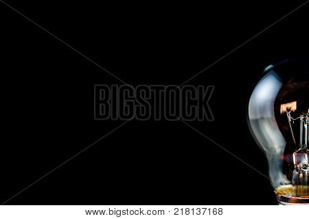Incandescent half light bulb isolated on black.