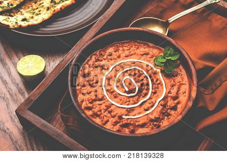 Dal makhani or dal makhni is a popular food from Punjab / India made using  whole black lentil, red kidney beans, butter and cream and served with garlic naan or Indian bread or roti