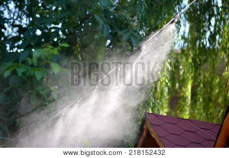 Irrigation system close-up. Humidification of air by steam on the street outdoor in a hot summer day morning