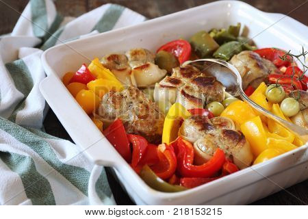 Stewed meat paupiettes with bell peppers in ceramic bakeware rustic style