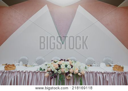 Minimalistic wedding table for the bride and groom. Decorated with roses