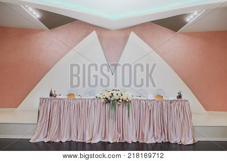 Minimalistic wedding table for the bride and groom. Decorated with roses