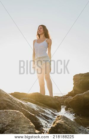 beautiful woman standing on the stone in the dawn