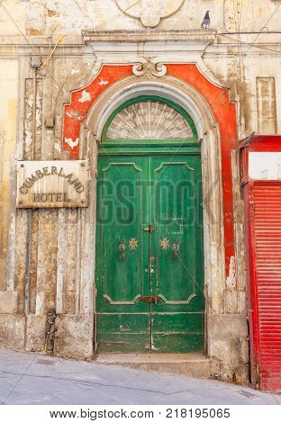 VALLETTA MALTA - JUNE 26 2012: The old green wooden door of the Cumberland Hotel in Valletta in Malta suggests a grander past.