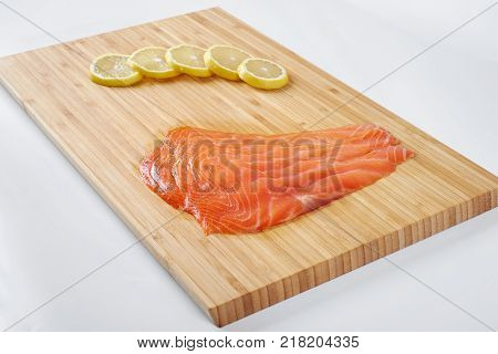 Smoked Fillet salmon with lemon on a board. Seafood.