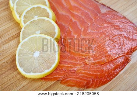 Smoked Fillet trout with lemon on a cutting board. Seafood.