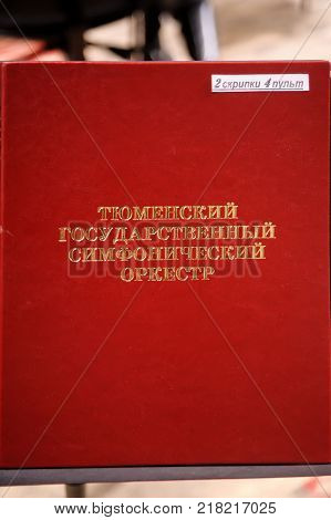 Tyumen, Russia - January 25, 2017: Concert of orchestra of the Tyumen philharmonic hall for photographers. The folder with notes for playing a violin. Russian text: Tyumen state symphonic orchestra