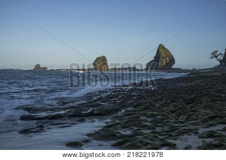 INDONESIA: Scenery of Tanjung Papuma Beach with rock and mossy foreground. Papuma beach is located at Jember,Surabaya, East Java.