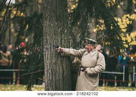Gomel, Belarus - November 26, 2017: Reenactor In Form Of Revolutionary Soldier Shoot Nagant M1895 Revolver On Celebration For The Century Of October Revolution.