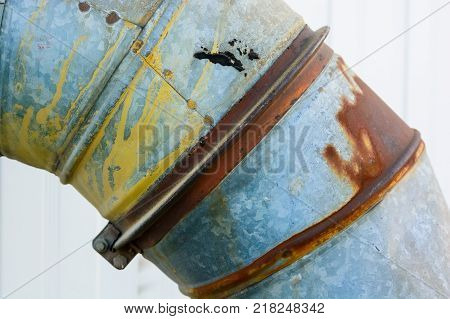 Close up obsolete rusty metal pipe on wall of factory