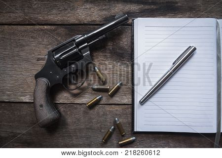 Gun and ammunition on wooden table. top view