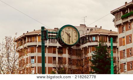 A green clock in the city. Half past ten