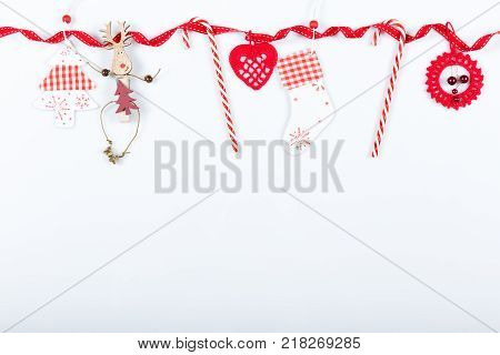 Christmas holiday composition. Festive creative red pattern, xmas handmade decor holiday with ribbon, candy canes, gift, christmas tree and decorations on white background. Flat lay, top view