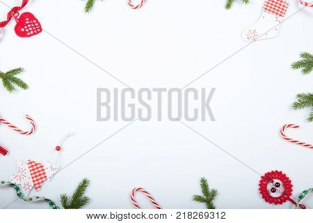 Christmas holiday composition. Festive creative red pattern, xmas handmade decor holiday with ribbon, candy canes, gift, christmas tree and decorations on white background. Flat lay, top view
