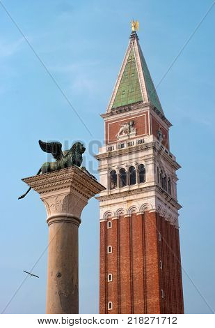 Lion of Venice and San Marco Campanile - St Mark's bell tower in the St Mark's bell tower, located on the Piazza San Marco in Venice, Italy Close up.