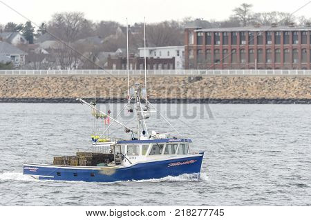 New Bedford Massachusetts USA - December 12 2017: Fishing vessel Intimidator on Acushnet River with New Bedford backdrop
