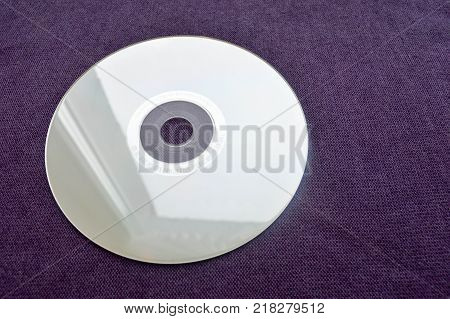 Brilliant compact disc. CD DVD Bluray disc on a violet background.